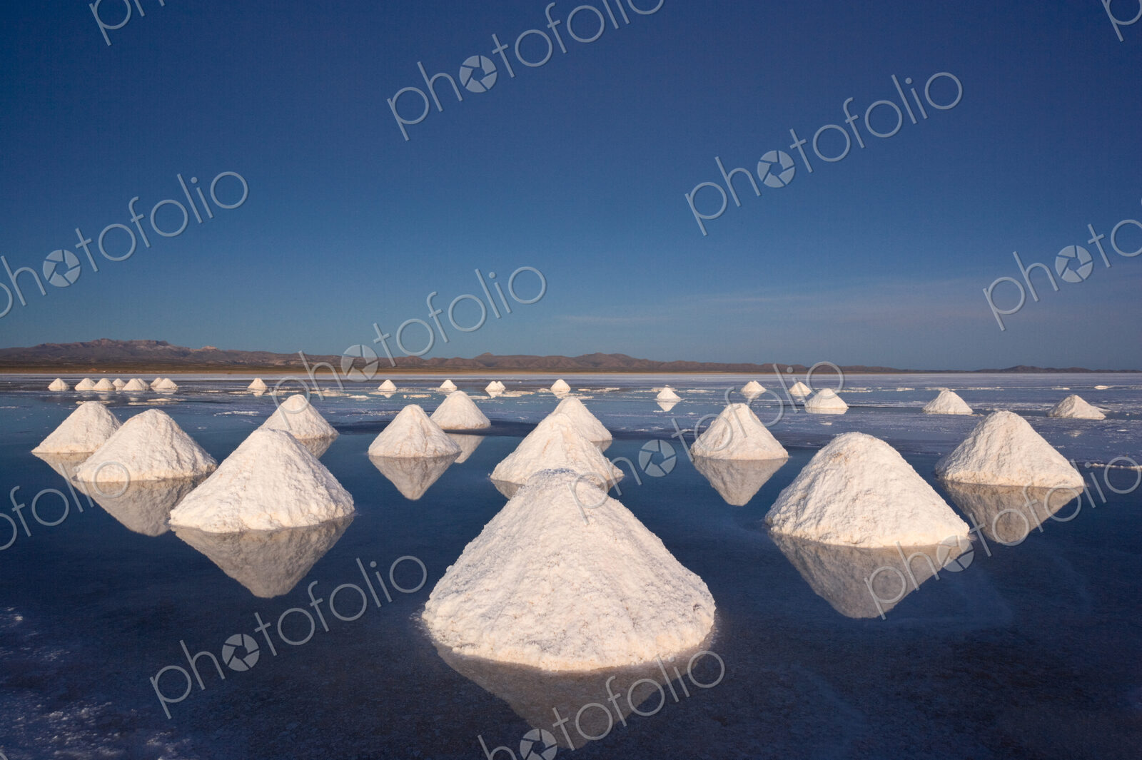 Piles of salt dry in the arid atmosphere of Bolivias Salar de Uyuni.